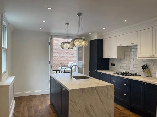 a kitchen with blue cabinets and a sink and a counter at Castle View House in Lincolnshire
