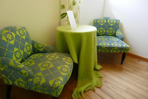 a table with a green cloth next to two chairs at B&B La ferme de Berwausault in Herve