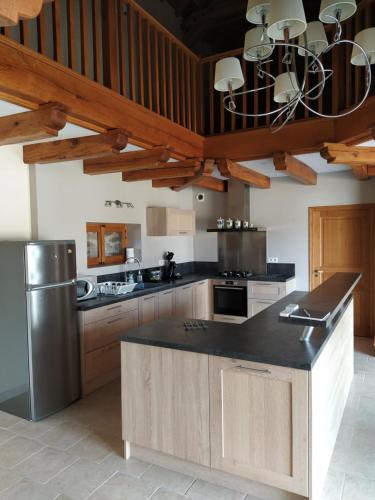une cuisine avec des armoires en bois et un comptoir noir dans l'établissement Maison Céras, à Lédergues