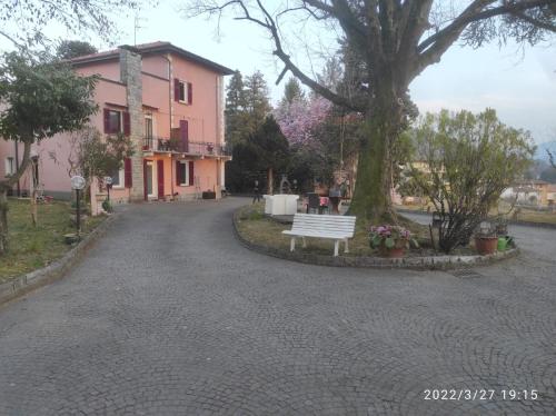 un banc blanc assis devant une maison rose dans l'établissement Villa Monica, à Luino