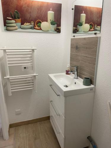 La salle de bains est pourvue d'un lavabo, d'un miroir et de bougies. dans l'établissement Soleil des Marquises, à Frontignan