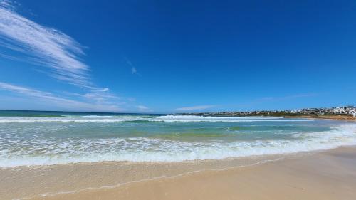 a beach with a blue sky and the ocean at Beachside in the heart of St Francis Bay Village in St Francis Bay