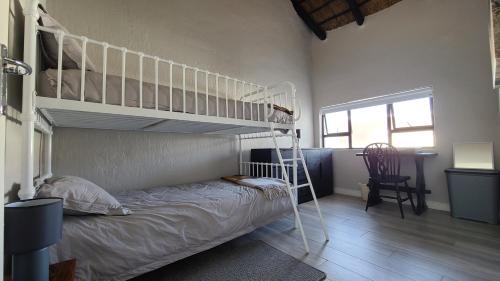 a bedroom with a bunk bed with a ladder at Beachside in the heart of St Francis Bay Village in St Francis Bay