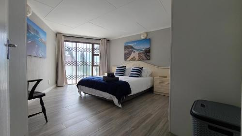 a bedroom with a bed and a large window at Beachside in the heart of St Francis Bay Village in St Francis Bay