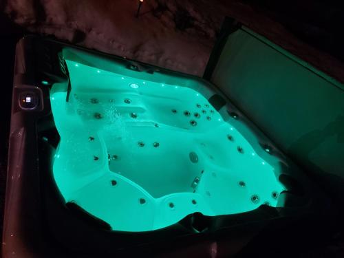 a green bath tub in a dark room at Appartement Harmonie & Balance in Leogang
