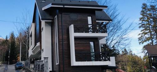 Una pequeña casa con un balcón en el lateral. en Casa Larisa - Wolves Apartment, en Sinaia