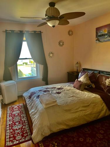 a bedroom with a bed and a ceiling fan at Stylish, Cozy 2BR Private Apt, 2nd Floor, Scenic View, Well-Appointed, Near Providence, MA, RI Line, I-95 Access in Pawtucket