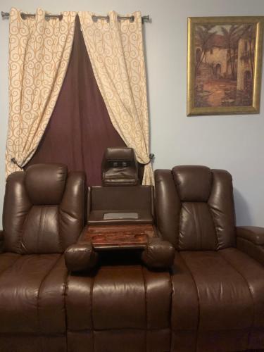 a brown leather couch with a laptop on top of it at The dream stylish apartment near Providence in Pawtucket