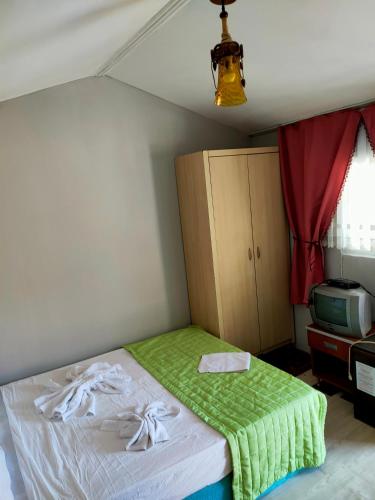 a bedroom with a bed with a green blanket at Side Erenler Hotel in Side