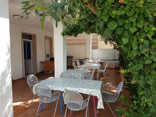 a room with tables and chairs and a hedge at PORTA NOVALIS Rooms in Novalja