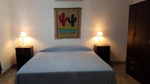 una camera con un letto con due comodini e due lampade di VICTORIA ANDINA I a Salta