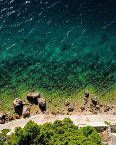 an aerial view of the ocean with rocks on the shore at Rumenović in Stanići