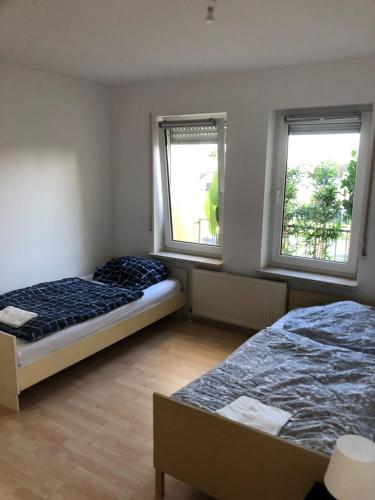 zwei Betten in einem Zimmer mit zwei Fenstern in der Unterkunft Monteurwohnung am Landgrafen in Worms