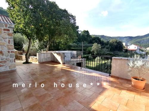 a patio with a fence and a tree on top at Merlo House Dol Hvar in Stari Grad