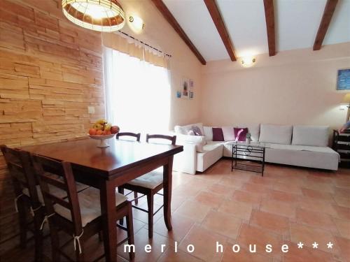 ein Wohnzimmer mit einem Tisch und einem weißen Sofa in der Unterkunft Merlo House Dol Hvar in Stari Grad