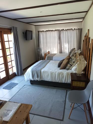 a bedroom with a bed and a table and a chair at Fig Tree in Colesberg