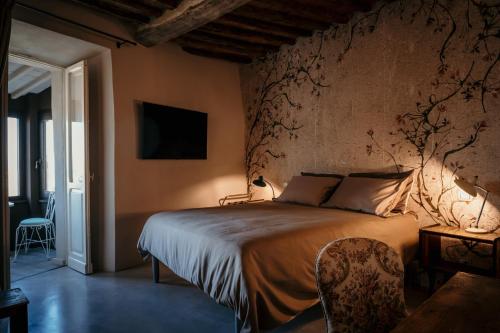 a bedroom with a bed and a tv on the wall at B&B La Castellina in Abbadia San Salvatore