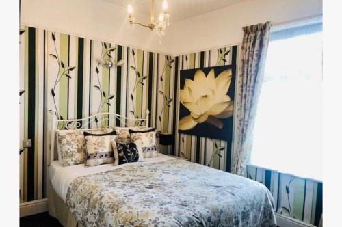 Un dormitorio con una cama y un cuadro en la pared. en Dunromin Hotel, en Blackpool