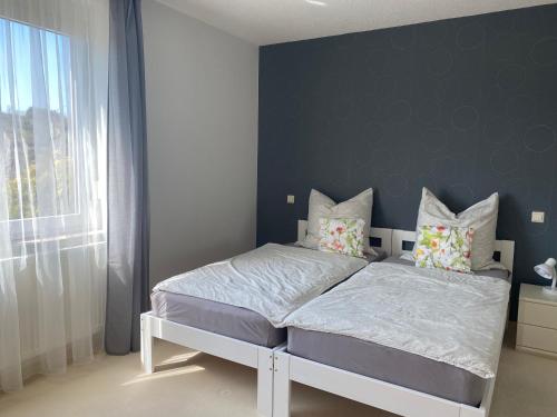 - une chambre dotée d'un lit avec un mur bleu dans l'établissement Ferienwohnung im Vorbachtal, à Niederstetten