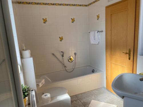 a bathroom with a tub and a toilet and a sink at Ferienwohnung im Vorbachtal in Niederstetten