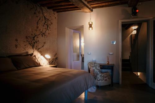 a bedroom with a bed and a chair and a door at B&B La Castellina in Abbadia San Salvatore