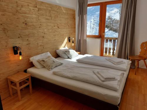 uma cama grande num quarto com uma parede de madeira em Chalet Peter em Zell am See