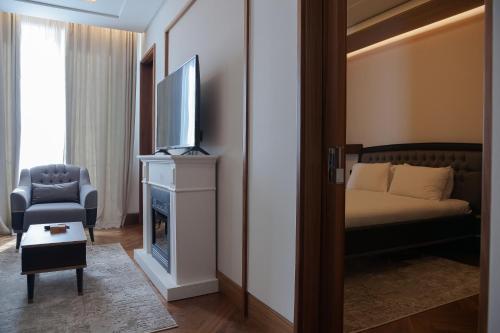 a room with a bed and a television and a chair at Porto Montenegro Luxury 1 Bedroom Apartment in Tivat