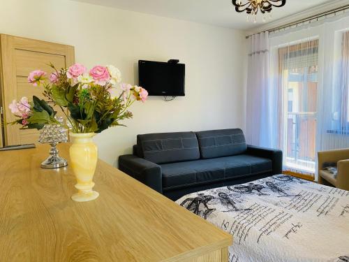 een woonkamer met een vaas met bloemen op een tafel bij Apartament Rodzinny Gubałówka in Zakopane