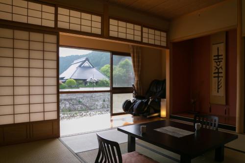 a room with a table and a large window at Okutsusou in Kagamino