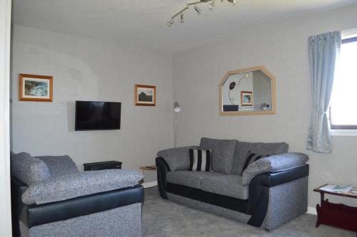 a living room with two chairs and a couch at Bachylis Self Catering in Kirkwall
