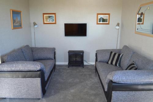 a living room with two couches and a flat screen tv at Bachylis Self Catering in Kirkwall