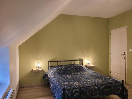 um quarto com uma cama e duas luzes na parede em Un nid pour la nuit em Bransles