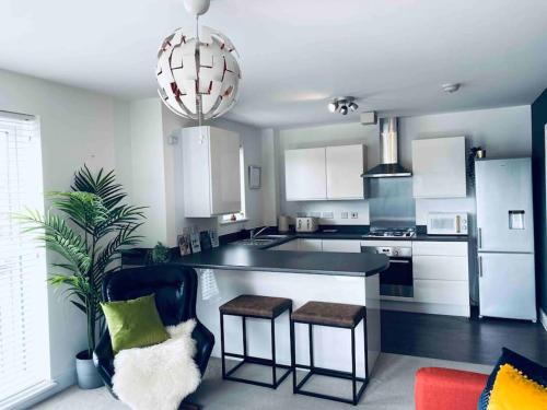 a kitchen with white cabinets and a black counter top at Luxury 2 Bedroom waterfront apartment with balcony in Newport