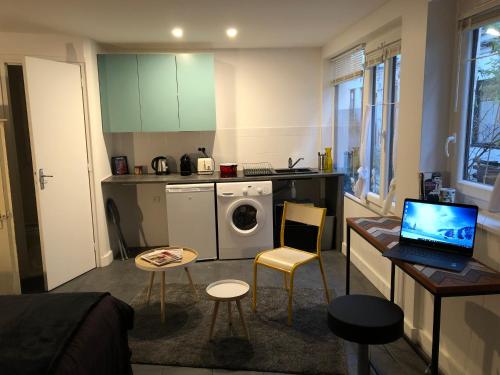 une petite cuisine avec un ordinateur portable sur une table dans l'établissement Cité Pilleux - Charming Studio in a flowery pedestrian lane, à Paris
