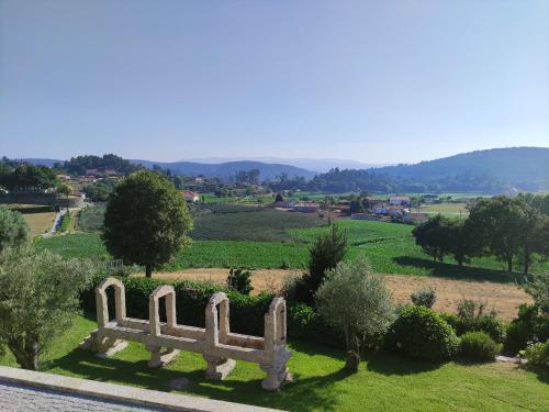 a stone bench sitting in a field with a view at Casa da Mata in Paredes de Coura