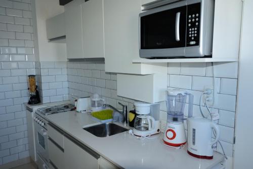 a kitchen counter with a sink and a microwave at Peatonal Apart in Bahía Blanca