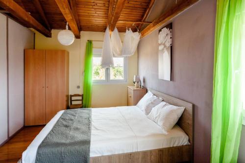 a bedroom with a large bed with green curtains at Sunny Peaceful Resort near the Sea in Stavros