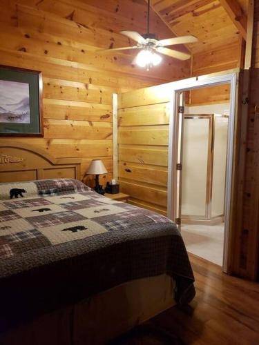 a bedroom with a bed and a ceiling fan at Beary Cuddly Hottub 10 Mins Downtown Gatlinburg National Park in Gatlinburg
