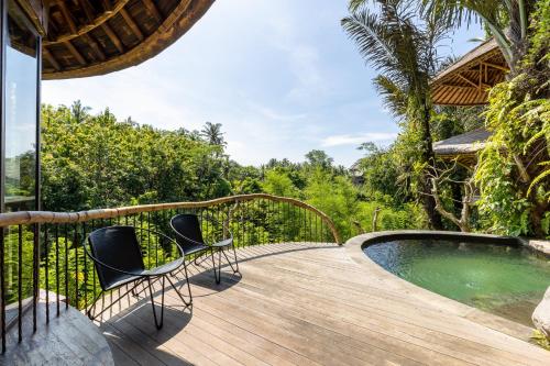 eine Holzterrasse mit Stühlen neben einem Pool in der Unterkunft Eclipse House 4bds Eco Bamboo House Pool RiverView in Bringkit