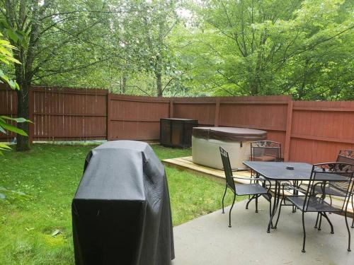 a backyard with a table and chairs and a grill at Beary Cuddly in Gatlinburg