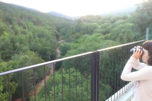 a woman taking a picture of a mountain valley at CASA SAPEIRÓ - Allotjament Rural in Cellers