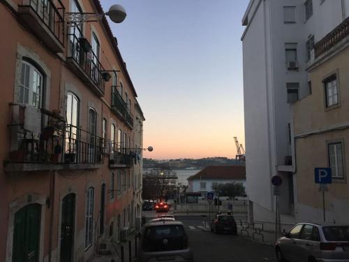 Cozy Estrela Apartment في لشبونة: شارع المدينة فيه مباني وسيارات تقف على الشارع