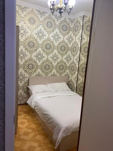 a small bed in a room with a wall at Gorgasali street Apartment in Batumi