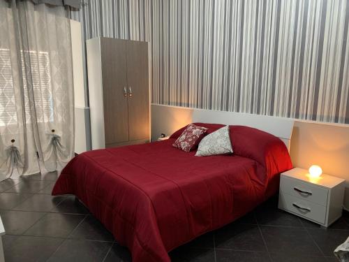 a bedroom with a large bed with a red blanket at Tarsia Suite in Naples