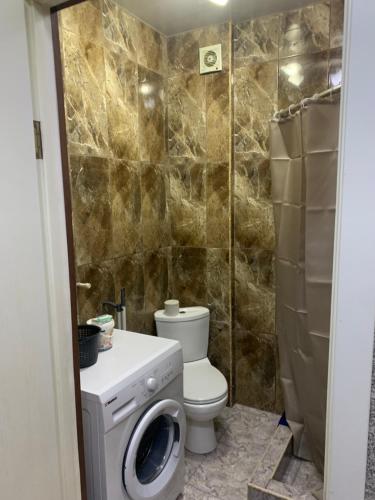 a bathroom with a toilet and a washing machine at Gorgasali street Apartment in Batumi