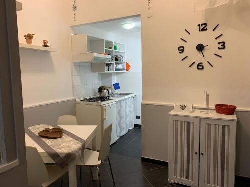 a kitchen with a table and a clock on the wall at Tarsia Suite in Naples