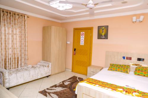 a bedroom with a bed and a yellow door at Bays Lodge, Accra in Accra