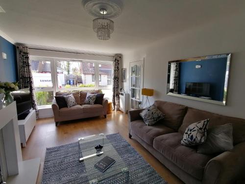 a living room with a couch and a tv at Delightful, central 3 bedroom house with garden & free parking in Inverness