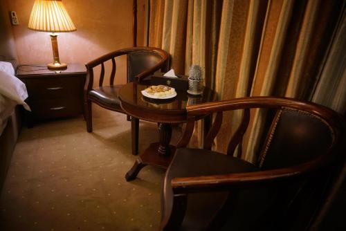 a room with a table and two chairs and a table and a lamp at 7 Wonders Hotel in Wadi Musa