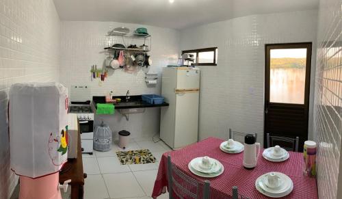 eine kleine Küche mit einem Tisch und einem Kühlschrank in der Unterkunft Duplex com 02 Suítes e Ar-Condicionados in Bananeiras